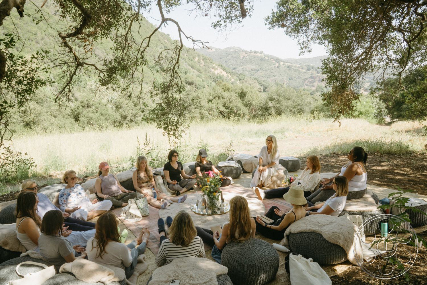Topanga Retreat - relaxed atmosphere, serene environment, surrounding hills, textured fabric cushions, rural landscape, open air setting, earth-toned decor, natural outdoor setting, natural light exposure, soft seating area, organic shapes of seating, wooden tree shade, open grassy field, group gathering, casual meeting space