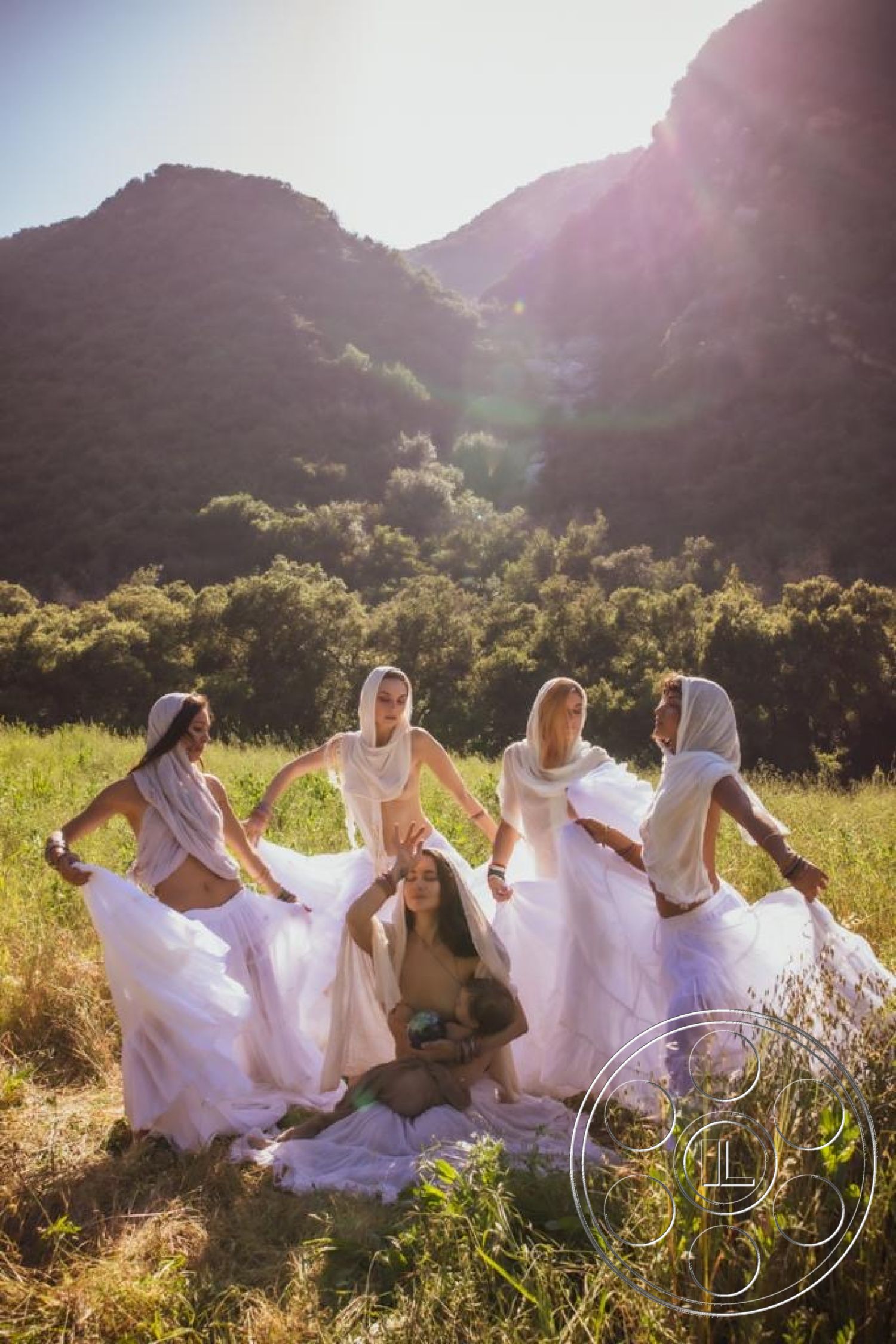 Topanga Retreat - mountain backdrop, natural landscape setting, luminous natural lighting, flowing white fabric garments, group of five figures, ethereal atmosphere, candid outdoor portrait, feminine figures in motion, serene grassy field, soft sunlight filtering through trees
