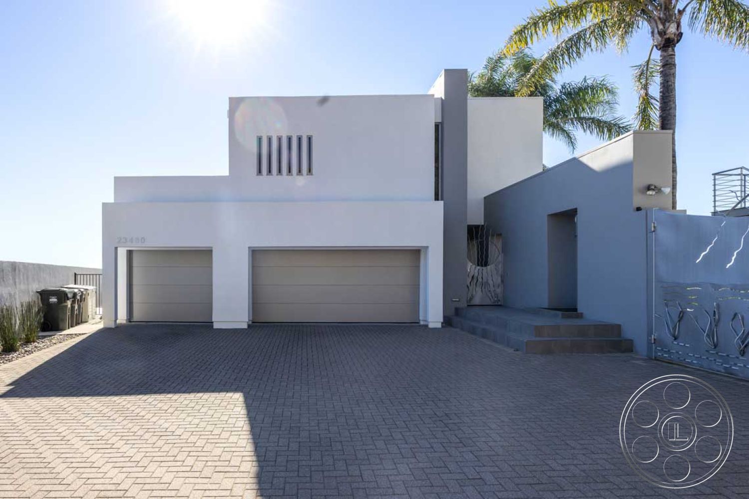 Modern 56 - contemporary style, exterior, landscaped garden, modern architecture, paver driveway, concrete stairs, architectural details, concrete driveway, tropical landscaping, sunny outdoor setting, two-story home, flat roof design, stucco exterior walls, minimalist facade, metal gate design, horizontal window slats, garage with smooth aluminum doors, urban location, palm trees in the environment, smooth wall textures