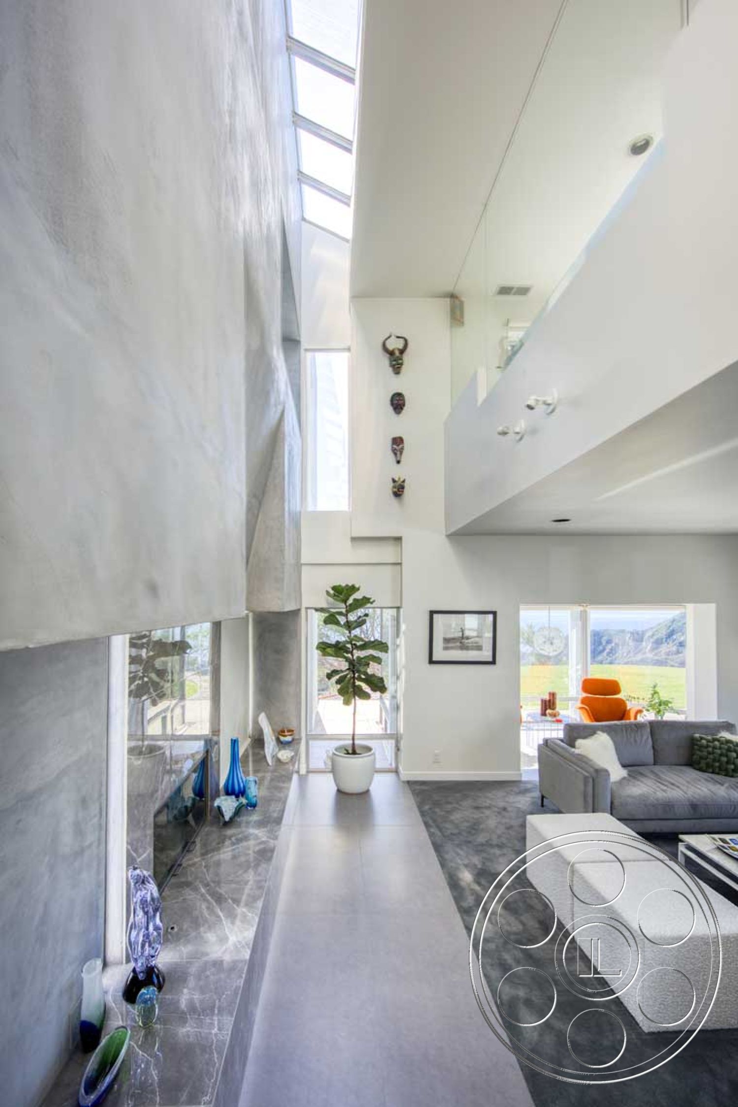 Modern 56 - large glass sliding doors, textured plaster walls, bright color accents, exposed structural elements, natural light illumination, contemporary design style, interior floor-to-ceiling windows, interior open concept living space, interior polished concrete flooring, interior glass partition walls, interior marble fireplace surround, interior minimalistic design elements, interior concrete walls, artwork gallery wall, interior plant accents, rectangular living area, modern couch, woven fabric accent chair, cubic coffee table, stylish decorative vases