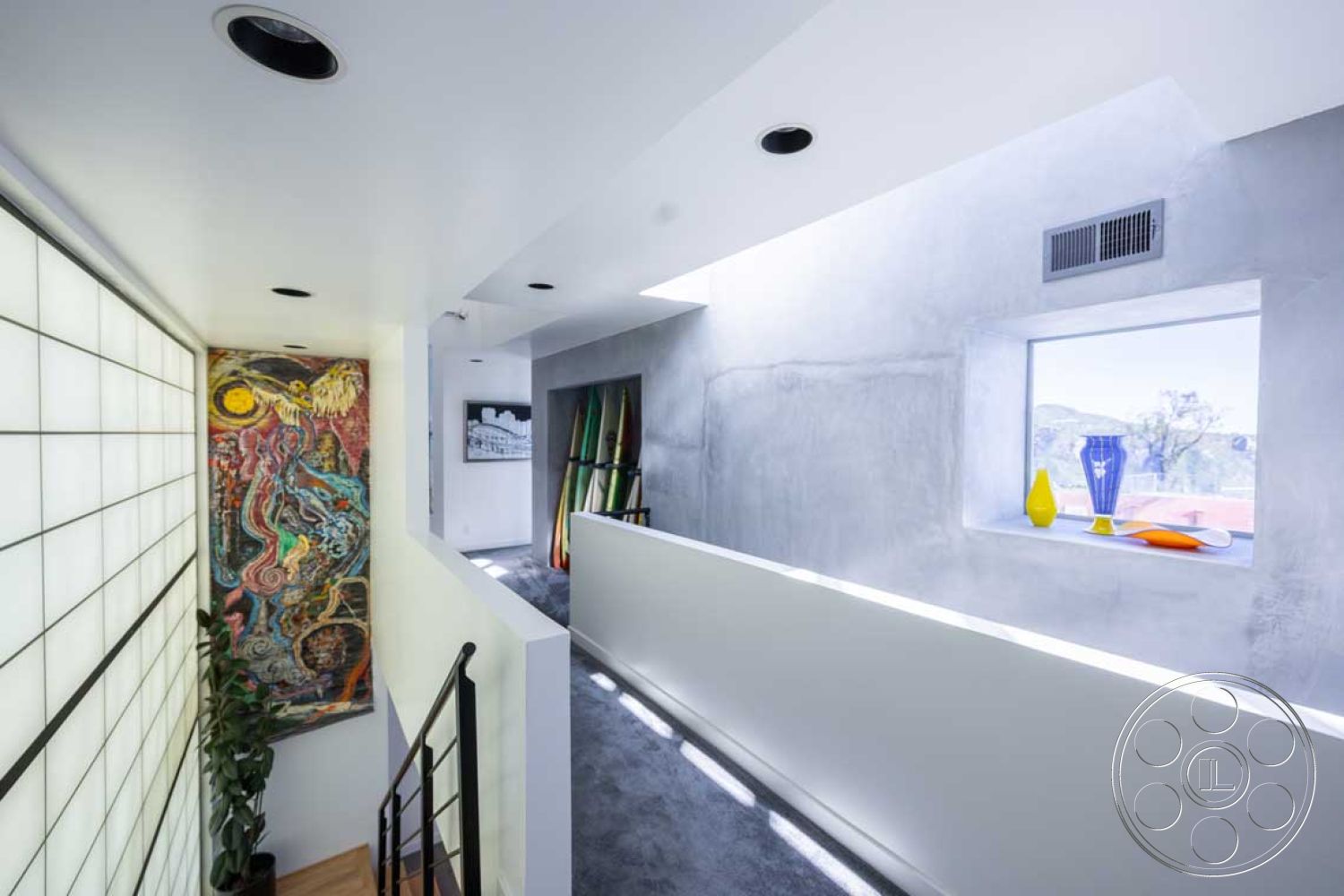 Modern 56 - interior - concrete walls, interior - concrete ceiling, interior - carpet flooring, interior - glass block wall, interior - vibrant wall art, interior - modern handrail, interior - recessed lighting, interior - large window with mountain view, interior - colorful decorative vases, interior - minimalist design, interior - open hallway, interior - natural light design