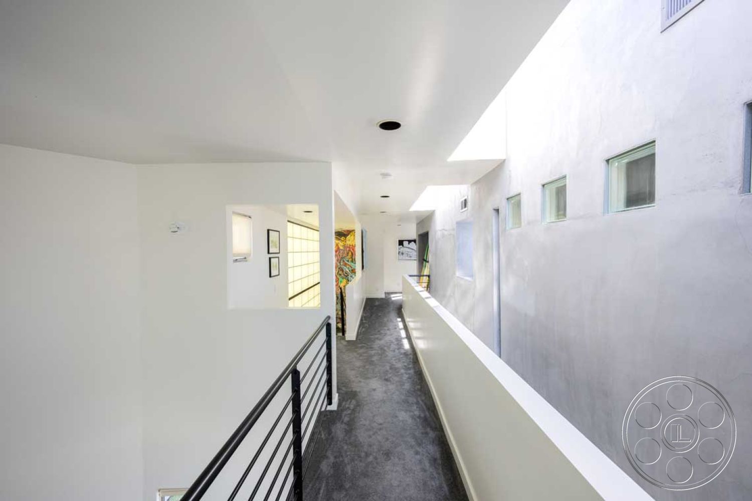 Modern 56 - open concept layout, rectangular windows, natural light from skylights, modern architectural details, geometric shapes in architecture, smooth white painted walls, interior hallway design, exposed concrete wall finish, concrete corridor floor, minimalist railing design, floating handrail, contemporary dwelling style