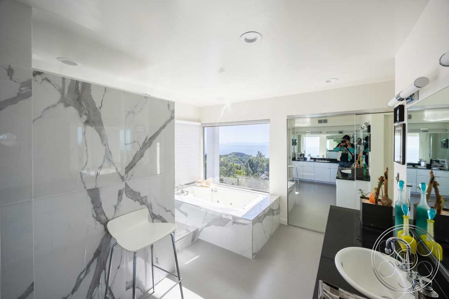 Modern 56 - large floor-to-ceiling windows, spa-like bathroom ambiance, interior marble bathroom walls, smooth white ceiling, mirrored bathroom wall, rectangular freestanding bathtub, marble bathtub surround, modern glass shower doors, black granite bathroom countertops, textured vinyl bathroom flooring, sleek contemporary bathroom cabinetry, minimalist chrome faucet fixtures, ocean view bathroom setting