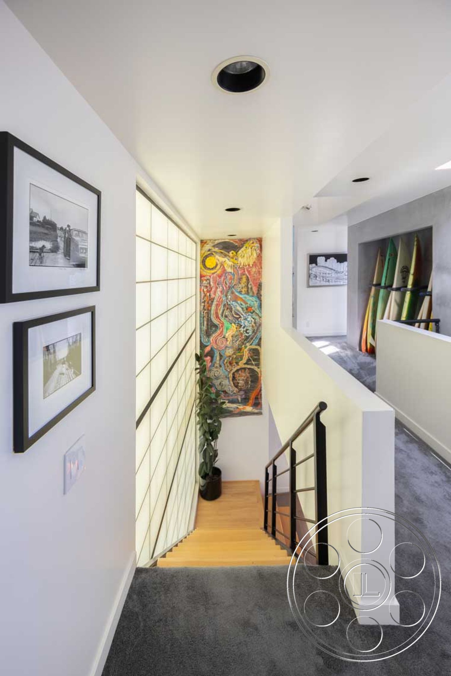 Modern 56 - soft neutral color palette, exposed wood ceiling beams, textured white painted walls, interior hardwood staircase, exterior glass partition wall, natural light-filled hallway, interior carpeted stair landing, interior wall art installation, modern minimalist interior design, contemporary railing design, interior decorative plant elements, cozy hallway with framed photographs, wood flooring in staircases, modern art transitions in design, staircase with straight design, artistic feature wall in corridor