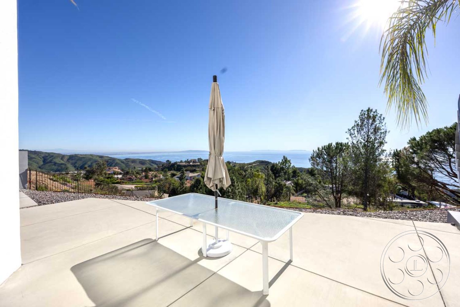 Modern 56 - exterior, glass sliding doors, modern outdoor furniture, landscaped hillside, mountain view, ocean view, umbrella shade, contemporary architectural style, concrete patio floor, rectangular patio