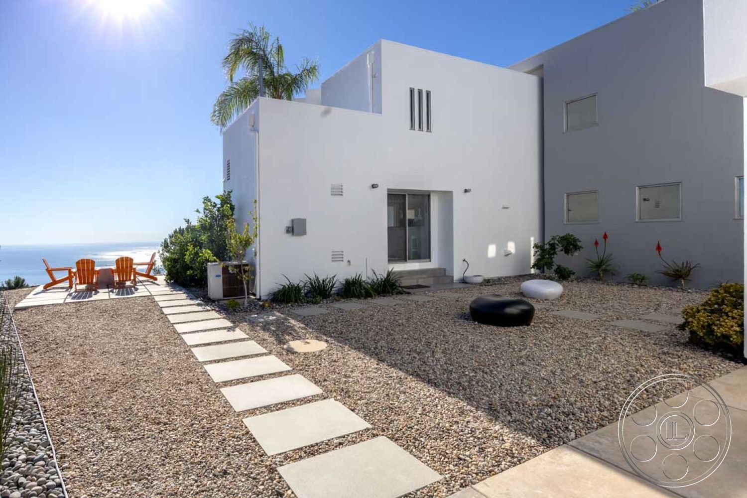 Modern 56 - exterior concrete walkway, exterior white stucco walls, exterior gravel landscaping, exterior glass sliding doors, exterior panoramic ocean view, exterior flat-roof modern home, exterior stone accent pathway, exterior clay tile patio, exterior terraced garden, exterior contemporary patio set, exterior natural stone planters, exterior angular architectural design