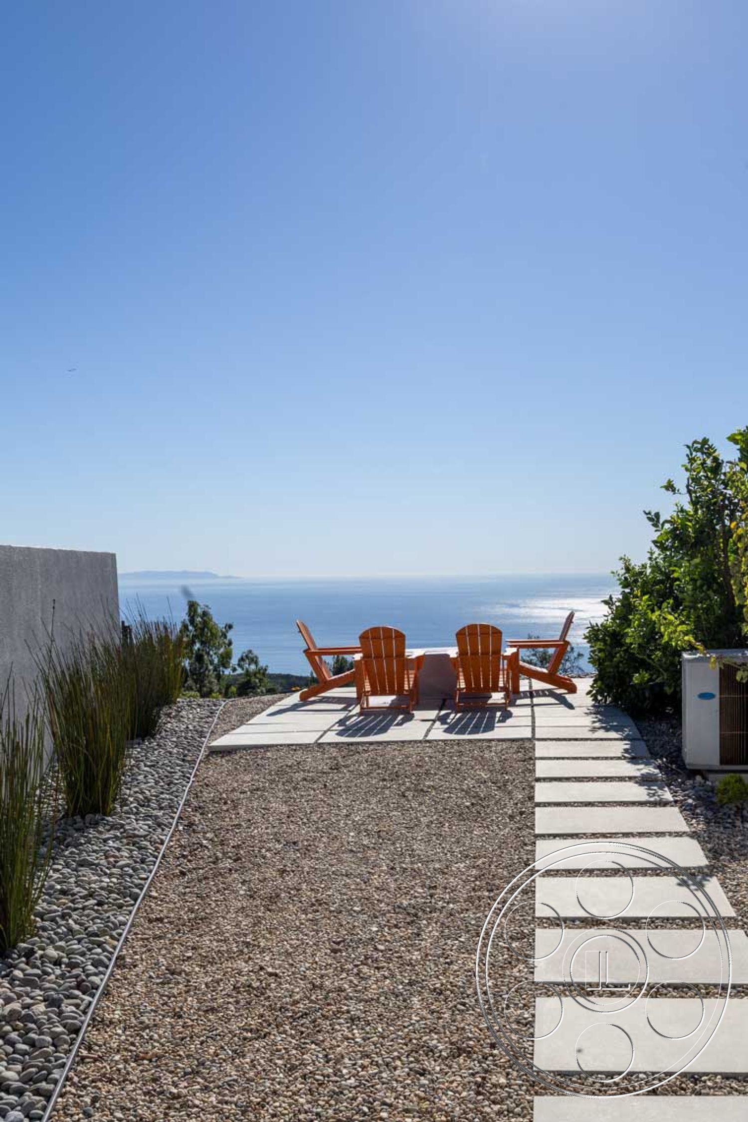 Modern 56 - exterior, low-maintenance plants, contemporary architecture, outdoor relaxation area, minimalist landscaping, open sky, gravel garden pathway, concrete patio area, modern outdoor living space, ocean view setting, stone stepping pads, terracotta adirondack chairs, coastal home design, sunny balcony view, level terrain