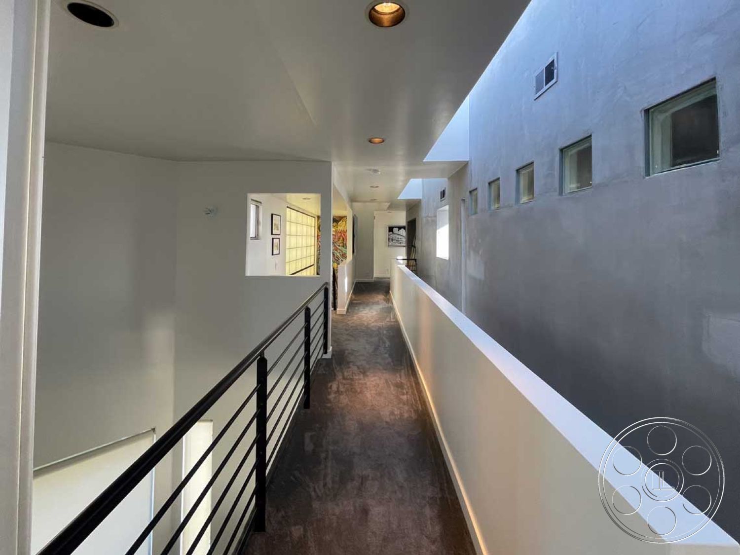 Modern 56 - large windows, concrete walls, interior hallway, white painted walls, minimalist architectural style, modern recessed lighting, wood laminate flooring, linear floor plan, textured plaster finish, black steel railing