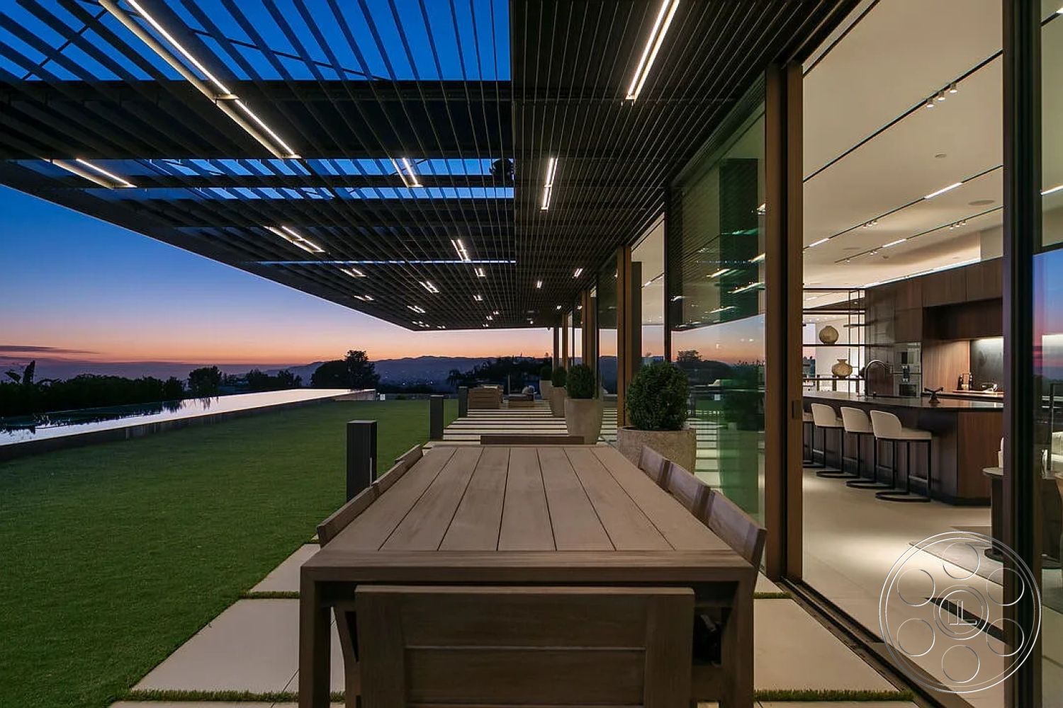 Modern 517 - wood dining table, glass sliding doors, floor-to-ceiling windows, outdoor dining space, concrete patio flooring, minimalist architectural style, landscaped grass lawn, steel frame construction, ambient LED lighting, rectangular infinity pool, exterior deck seating area, modern pergola structure, open-concept kitchen view, city skyline view at sunset, neutral-colored architectural materials, contemporary outdoor living experience