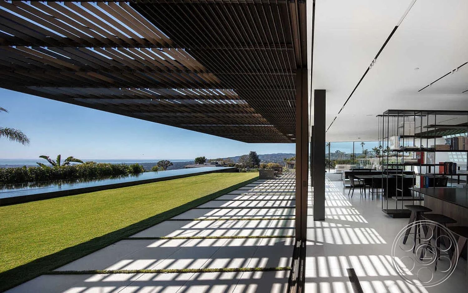 Modern 517 - landscaped garden view, floor-to-ceiling windows, open concept living space, sunlit interior, sleek outdoor furniture, high ceiling with recessed lighting, interior concrete flooring, contemporary outdoor lounge area, modern glass sliding doors, urban hillside setting, modern patio space, black steel railing, exterior wood slat pergola, linear outdoor water feature, rectangular lap pool, textured grass lawn, minimalist black kitchen cabinetry, geometric concrete pathway, architectural shading structure, coastal mountain view