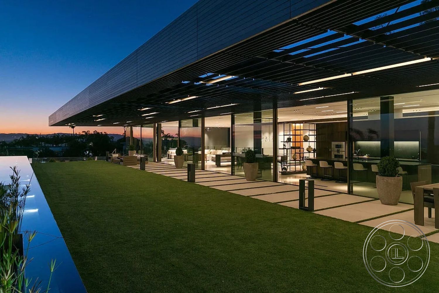 Modern 517 - modern landscaping, urban skyline view, open concept living space, concrete patio flooring, interior chef's kitchen, rectangular outdoor seating area, exterior glass walls, concrete pool edge, grass lawn area, metal roof overhang, minimalist structure design, floating planter boxes, horizontal louvered window treatments, smooth stone pathways, steel beam construction, illuminated outdoor spaces