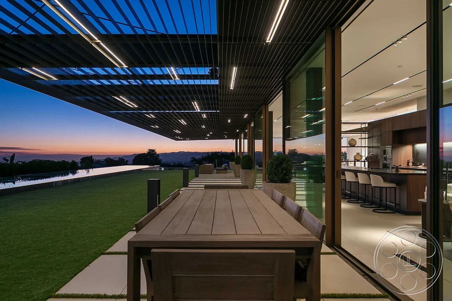 Modern 517 - high ceilings, exterior, minimalist aesthetic, wooden dining table, planter boxes, sunset view, outdoor entertaining space, steel structure, hardwood accents, contemporary kitchen, barstool seating, integrated outdoor lighting, concrete patio flooring, open-concept living area, modern architectural design, glass wall panels, landscaped lawn area, overhang pergola, elevated infinity pool