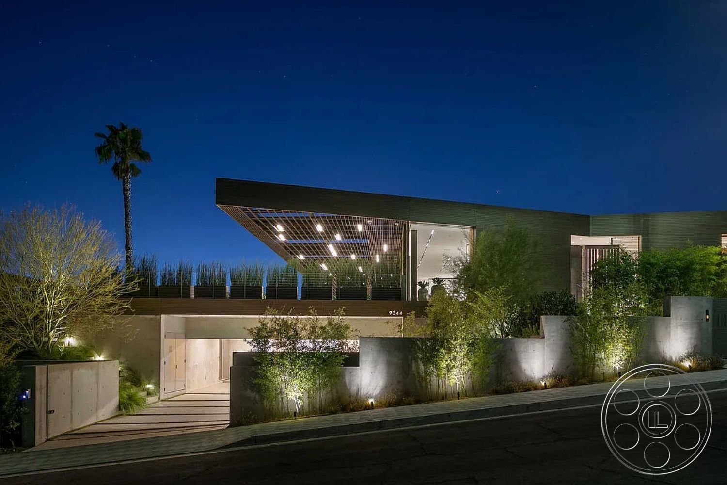 Modern 517 - exterior, modern architecture, minimalist design, concrete walls, urban setting, floor-to-ceiling windows, concrete driveway, natural stone steps, outdoor lighting fixtures, horizontal wood siding, nighttime illumination, glass entrance doors, landscaped garden with bamboo, wood slat canopy, slope from street, green roof elements