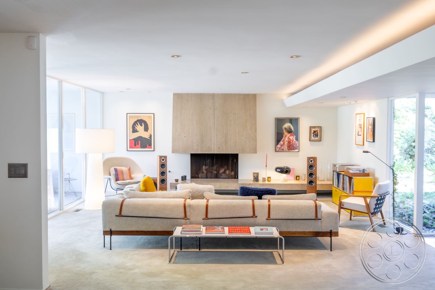 MCM 27 - neutral color palette, minimalist furniture, floor-to-ceiling windows, textured plaster walls, exposed ceiling beams, mid-century modern design, interior living room, integrated lighting fixtures, soft carpet flooring, bright yellow accent furniture, geometric furniture shapes, concrete fireplace surround, hardwood accent details, bright open layout, contemporary art displays