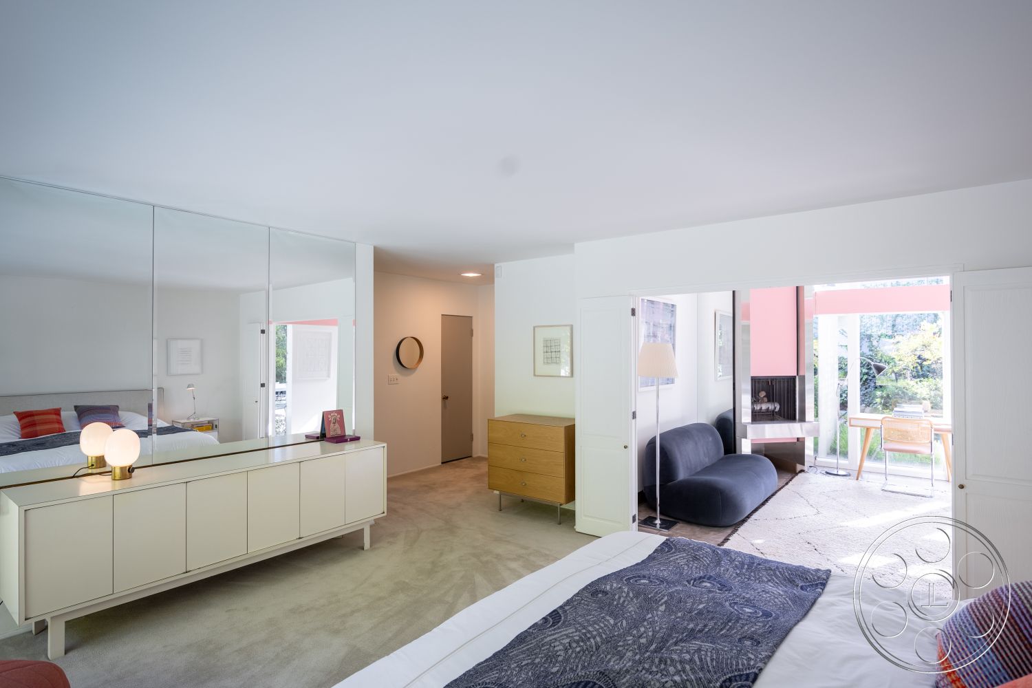 MCM 27 - flat ceiling with recessed lighting, curved modern sofa, decorative wall mirrors, neutral color palette with pops of color, floor-to-ceiling windows providing natural light, textured throw blanket on bed, interior bedroom with carpet flooring, modern dresser with clean lines, mirrored wall reflecting light and space, minimalist lighting fixture on nightstand, open concept room with direct access to outdoor area, sliding doors leading to patio, sparse contemporary art on walls, light wood furniture in Scandinavian style, subtle ambient lighting throughout, outdoor garden view from interior, contemporary style room design