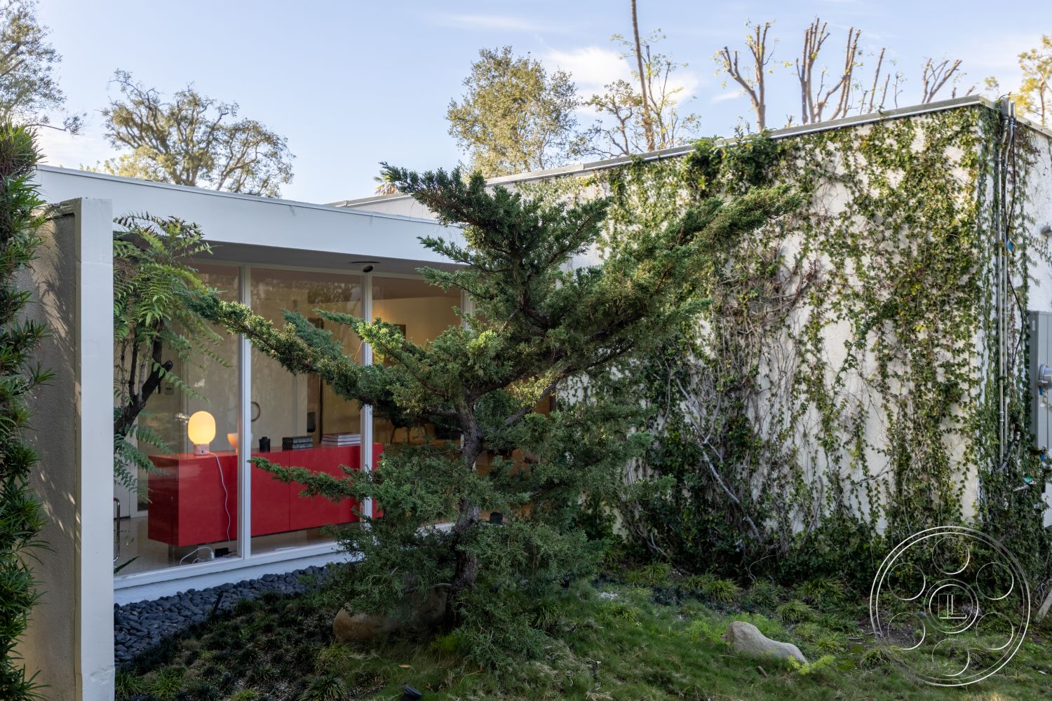 MCM 27 - exterior, low-maintenance landscaping, minimalist design elements, glass walls, modern architectural style, contemporary outdoor lighting, urban garden, flat roof design, landscaped garden area, lush greenery setting, floor-to-ceiling glass windows, concrete exterior walls, integrated indoor-outdoor living, simple geometric forms, river rock garden bed, greenery-covered wall, asymmetrical shaping, open-plan living space view