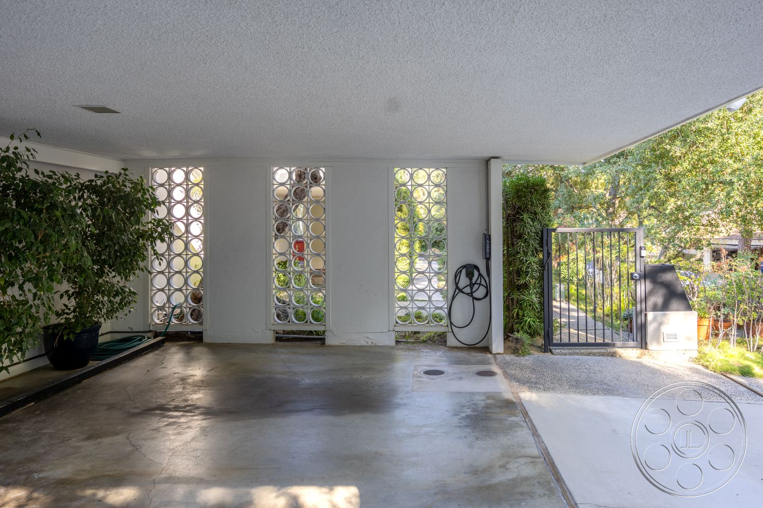 MCM 27 - minimalist aesthetic, landscaped garden view, modern architectural style, uncluttered space, potted indoor plants, concrete garage floor, textured ceiling finish, natural light entry, glass block windows, exterior garage space, steel outdoor gate, open garage design, underground parking, curated outdoor pathway