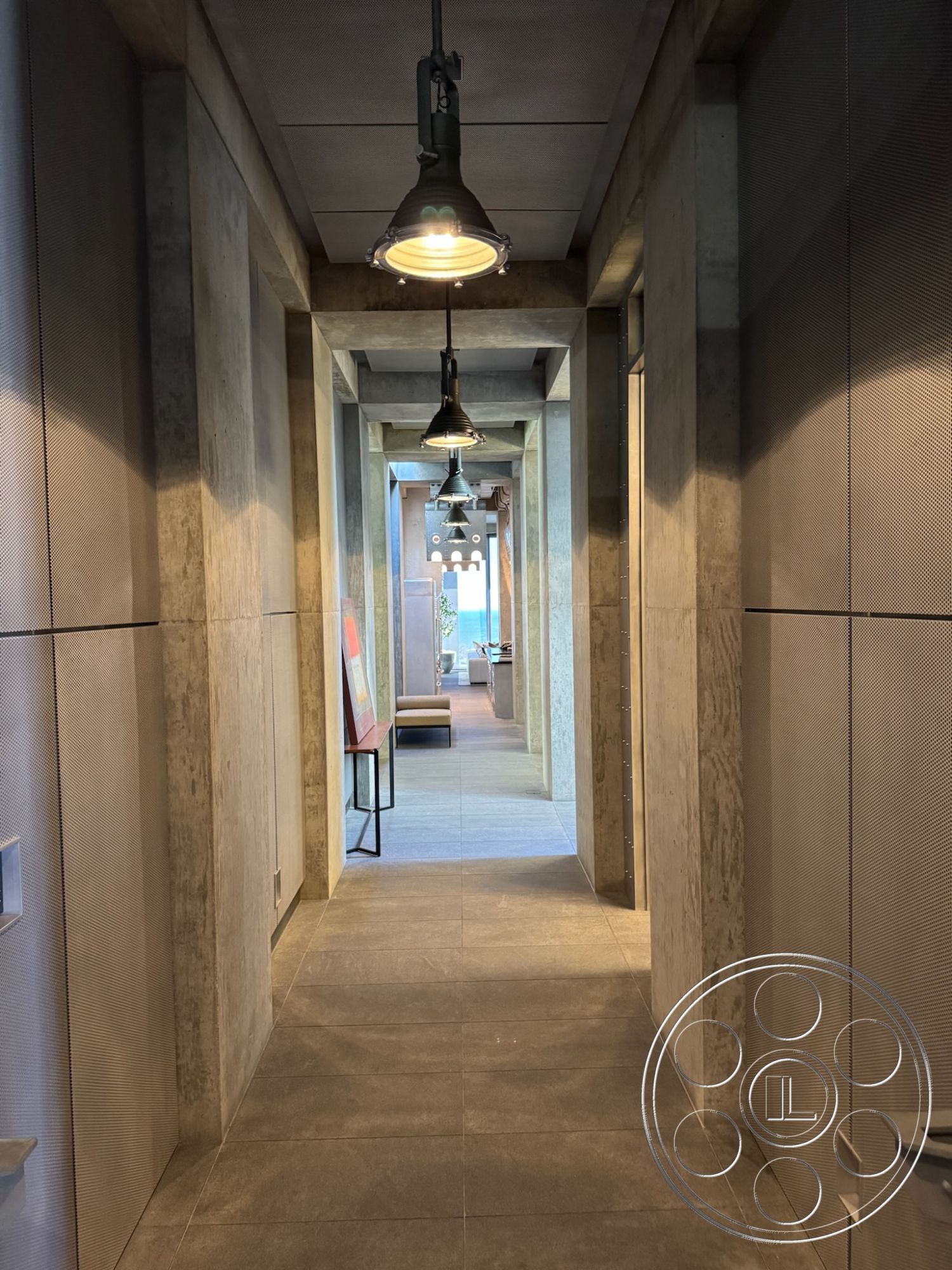 Fortress - neutral color palette, floor-to-ceiling windows, contemporary architectural style, minimalist interior design, exposed concrete walls interior, open hallway layout, flush mount ceiling lights, textured plaster wall accents, polished concrete flooring interior, hanging industrial pendant lighting, rectangular ceiling design, long narrow corridor, modern furniture decor, functional hallway space