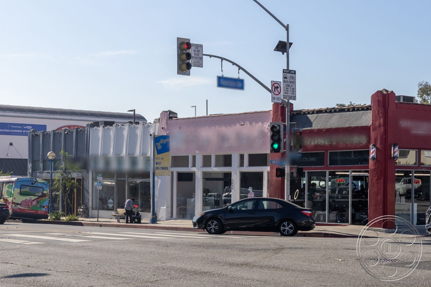 Gym 37 - exterior, stucco facade, business signage, commercial building design, glass storefront windows, urban street view, metal panel storefront, red-painted stucco wall, pedestrian seating area, traffic signal installation, city sidewalk, planting area with greenery, light pole installation