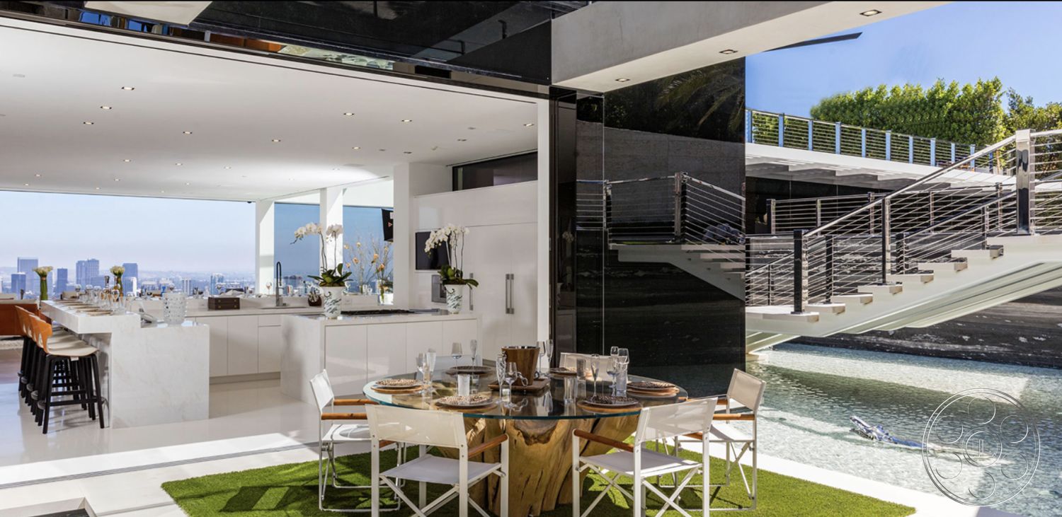 Modern 518 - interior white painted walls, interior marble kitchen island, interior open floor plan layout, interior glass sliding doors, exterior glass railing, exterior infinity pool, setting hillside location, exterior city skyline view, architectural contemporary style, exterior steel stair railings, interior concrete patio flooring, interior hardwood dining table, interior designer bar seating, interior modern dining chairs, exterior landscaped terrace, structural floor-to-ceiling windows, structural vaulted ceilings, room function chef's kitchen, room function outdoor dining area, setting urban rooftop