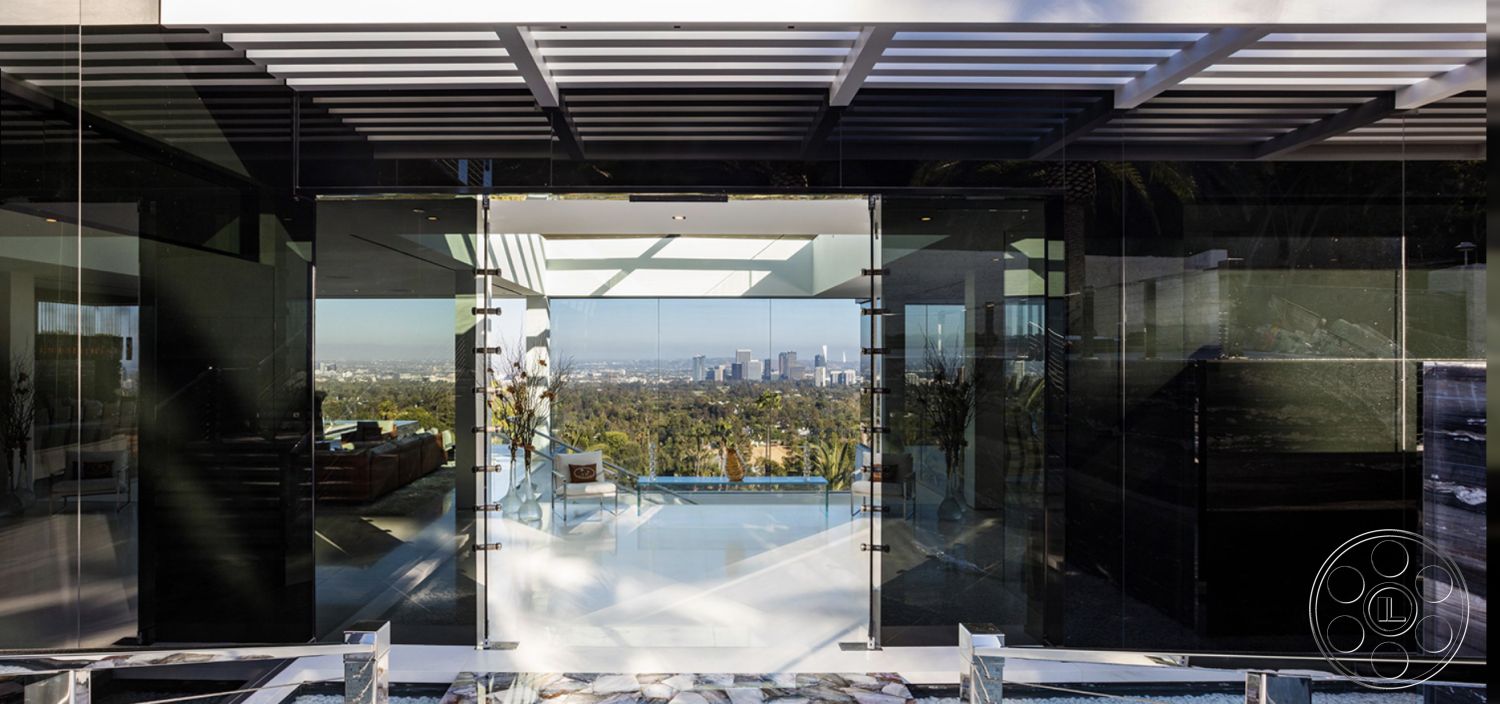 Modern 518 - contemporary design elements, black stone accents, horizontal wood slat roof overhang, open floor plan living area, stone feature wall interior, exterior minimalist design, modern outdoor living space, sleek tile flooring, city skyline view from patio, interior glass door entrance, concrete patio with glass doors, steel and glass architectural details, infinity pool view, larger floor-to-ceiling windows, exposed ceiling beams in living space, luxurious modern home entrance