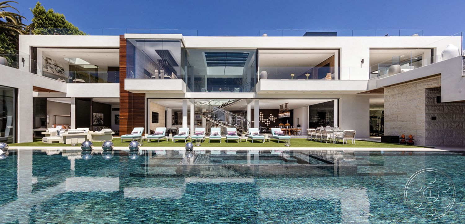 Modern 518 - landscaped garden, modern exterior, open-air living space, large floor-to-ceiling windows, horizontal wood paneling, concrete pool deck, exposed wood ceiling beams, stucco exterior walls, minimalist architectural style, rectangular infinity pool, glass door entry, tile patio flooring, glass railing terrace, urban mountain view, luxury outdoor lounge area, bright sunny environment, sleek white exterior, large patio with chaise lounges