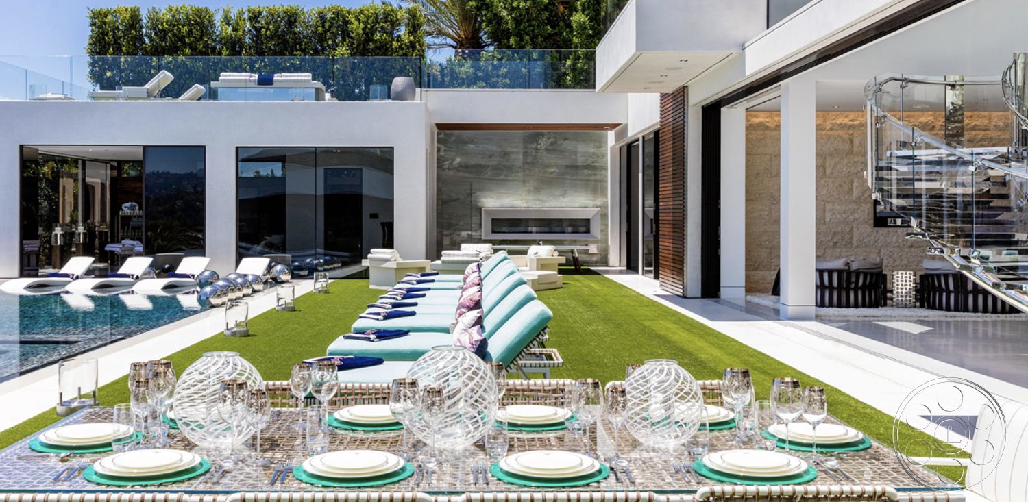 Modern 518 - exterior landscaped garden with palm trees, interior dining area with glass tableware, exterior grass lawn with modern chaise lounges, interior glass sliding doors providing pool view, exterior infinity pool with sleek concrete edge, exterior stacked stone feature wall, exterior glass railing for poolside deck, interior stainless steel spiral staircase, interior open living space with vaulted ceiling, exterior contemporary patio with grass patches, interior modern fireplace with stone surround, exterior lounge area with outdoor seating, exterior natural stone pathways, interior minimalist design with clean lines, exterior textured wall with wood accents, exterior glass partition walls for seamless view, interior tiled floor transitioning to outdoor space, exterior entertaining area with modern decor, interior recessed lighting for ambient glow, exterior open-concept layout with seamless flow