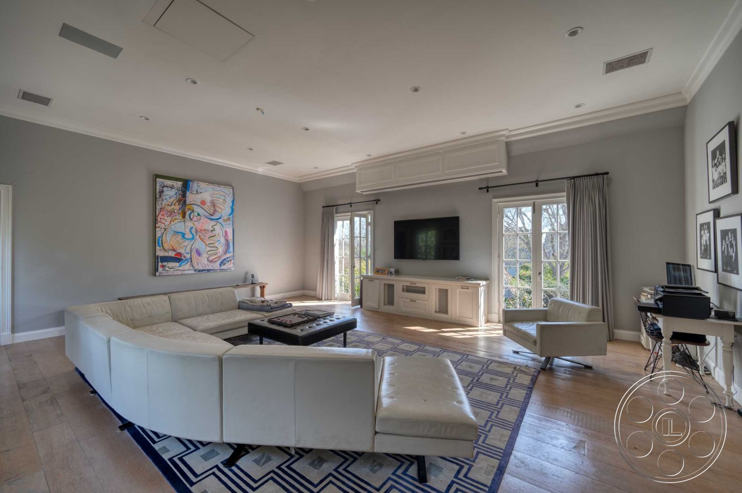 The French Chateau - contemporary decor, light hardwood flooring, open floor plan, floor-to-ceiling windows, casual seating area, black coffee table, recessed ceiling lighting, interior living room, natural light-filled space, crown molding details, gray painted walls, modern design aesthetics, white leather sectional sofa, large abstract wall art, sheer drapery curtains, built-in entertainment unit