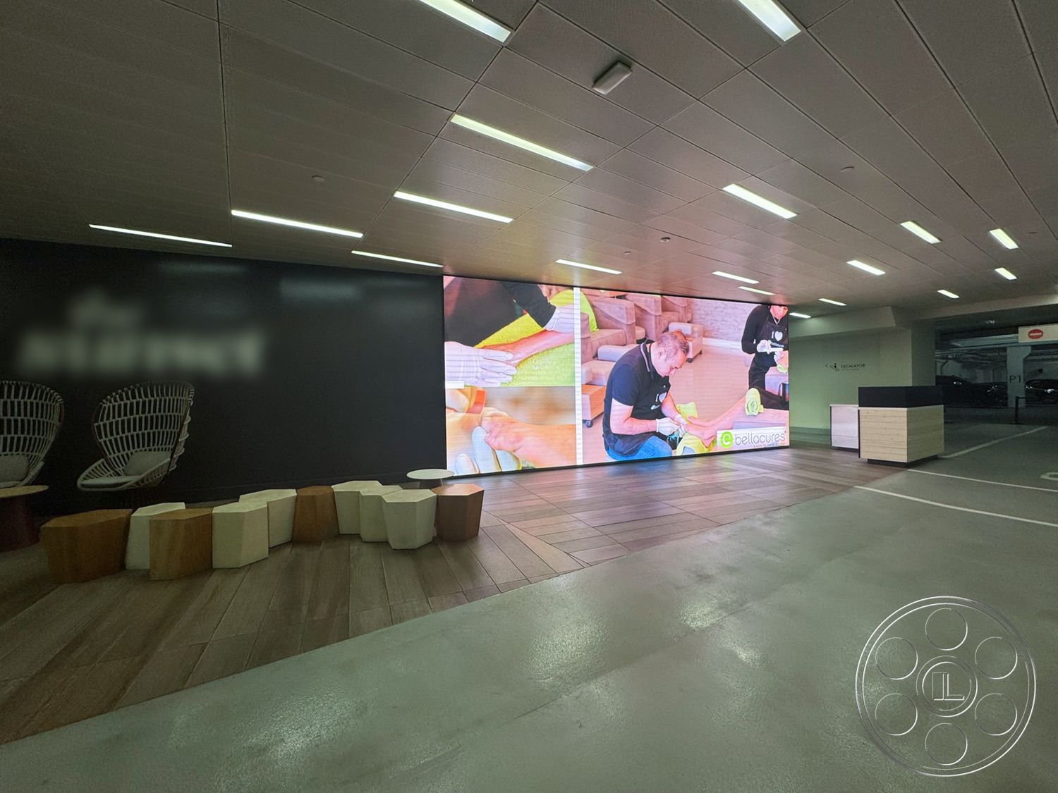 Sunset Storefront - neutral color palette, polished concrete floor, interior space, modern seating area, contemporary architectural style, urban commercial setting, minimalist reception desk, casual meeting space, textured wood panel flooring, large digital display wall, ambient LED ceiling lights, open lobby layout, sculptural seating design, natural wood and white composite furniture, curved chair shapes, geometric stool forms, exposed ceiling design