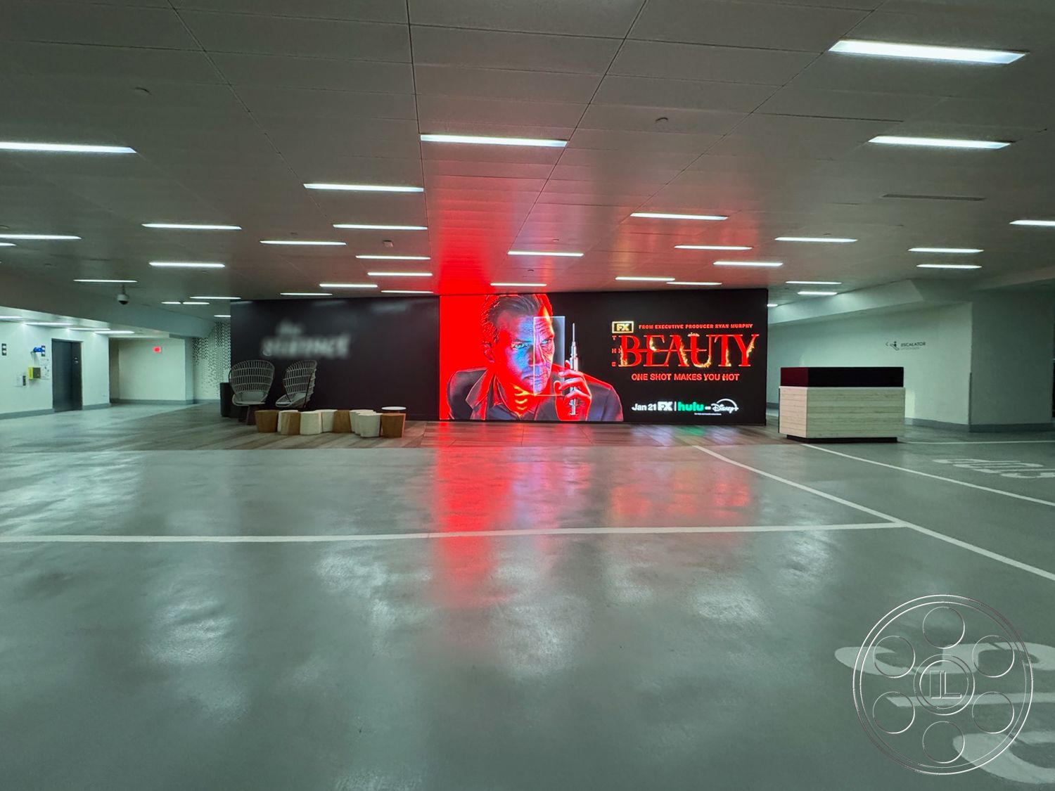 Sunset Storefront - concrete block walls, textured wall treatment, open-plan layout, ambient lighting fixtures, minimalist architectural style, concrete ceiling panels, exterior concrete parking floor, interior LED wall display, modern seating area with wood accents, steel and wood reception desk, contemporary lounge chairs, sparse furniture arrangement, industrial aesthetic with smooth surfaces, urban setting with functional design, high-gloss epoxy flooring