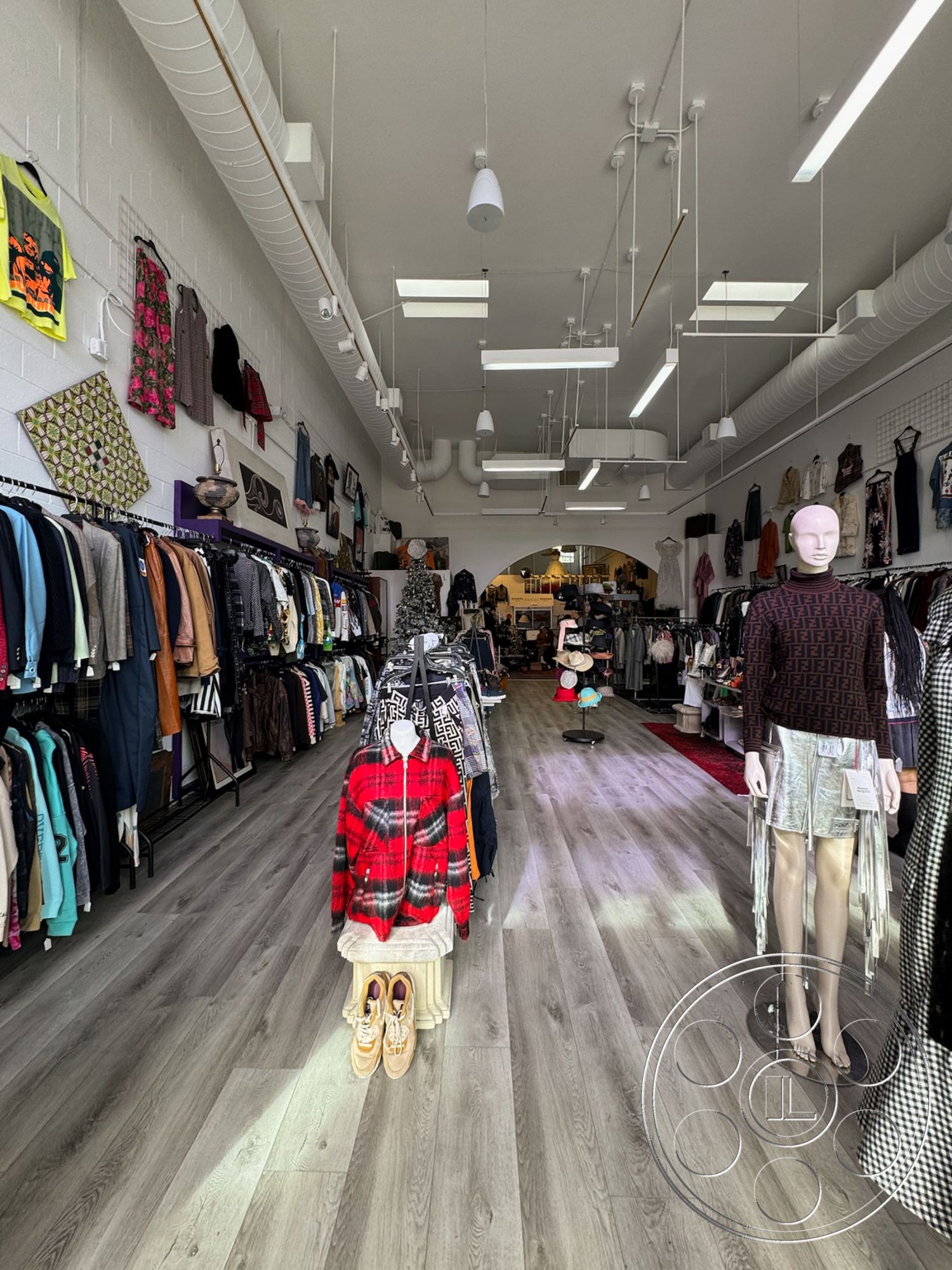 Melrose Store - textured wall finish, laminate flooring, clothing racks, track lighting fixtures, exposed ductwork ceiling, bright interior lighting, mannequin display, interior clothing store, rectangular display layout, soft goods merchandising, window display area, fashion retail space, contemporary store design, urban boutique setting