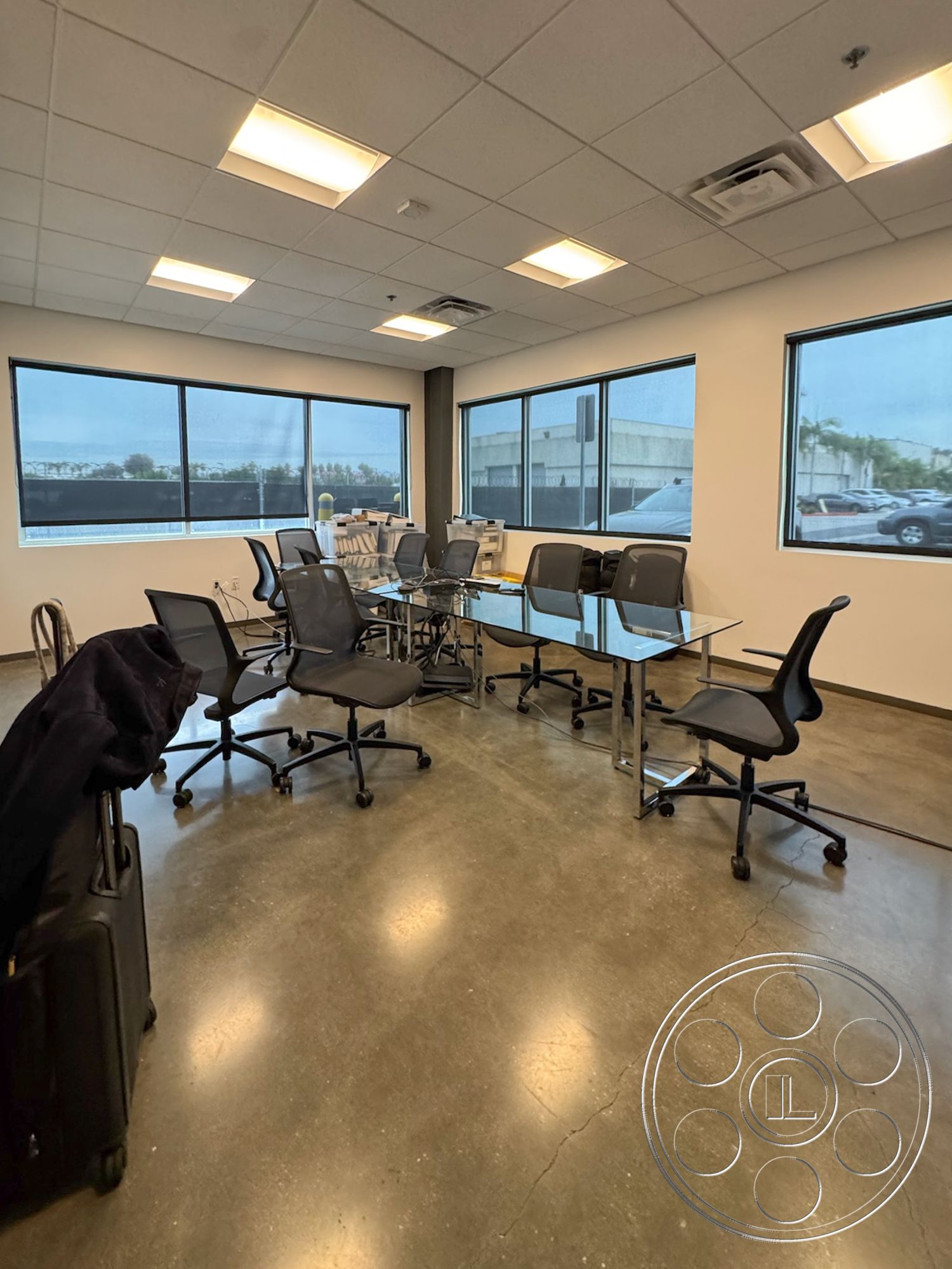 HW Hangar - neutral color palette, minimalist aesthetic, open workspace, collaborative environment, modern office design, contemporary office layout, black ergonomic office chairs, glass conference table, drop ceiling with fluorescent lights, polished concrete office flooring, large windows with industrial view, workstation arrangement