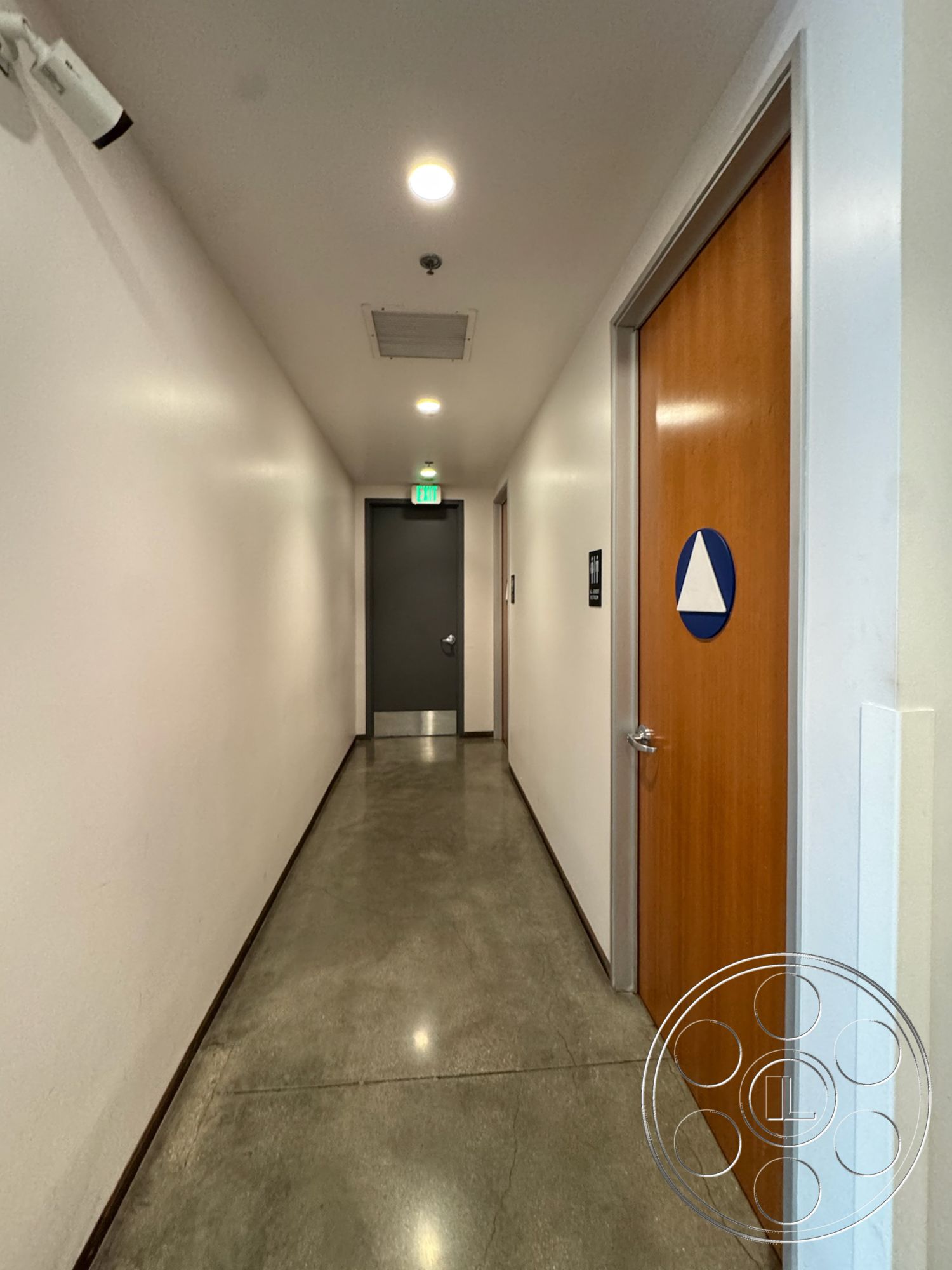 HW Hangar - neutral painted walls, minimalist architectural details, modern corridor design, suspended ceiling with recessed lighting, security camera installation, metal door hardware, dimensional signage, polished concrete hallway floor, exposed concrete wall finishes, solid wood interior doors, industrial-style hallway, dark gray interior door, open space planning, functional interior layout