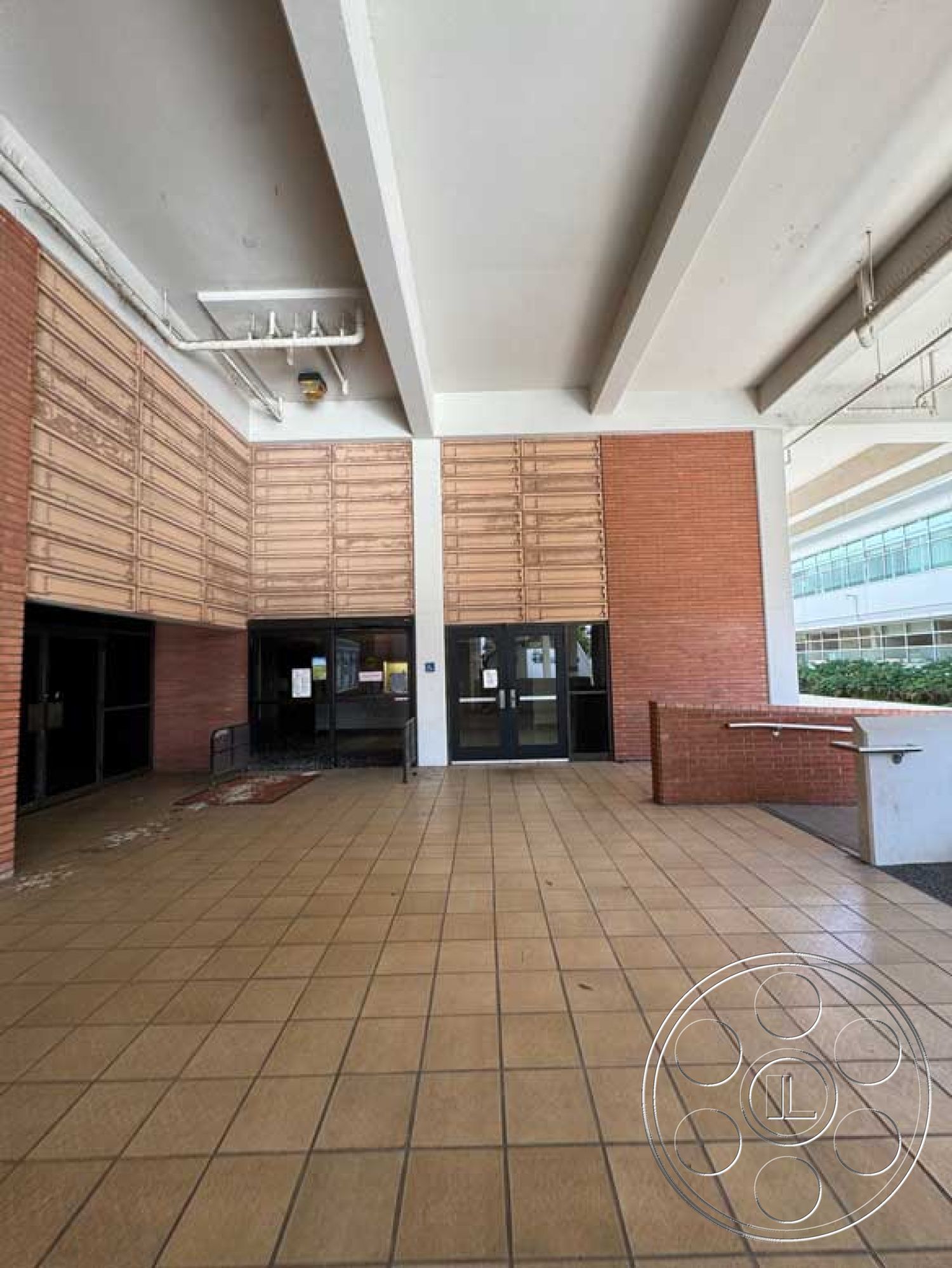 Old School - landscaped view, modern architectural style, exposed concrete ceiling, urban commercial setting, wood panel wall treatment, exterior entrance area, concrete ramp access, brick wall cladding, glazed double entrance doors, tile flooring in entryway, horizontal wood slat paneling, ground-level outdoor space, open-air entrance design