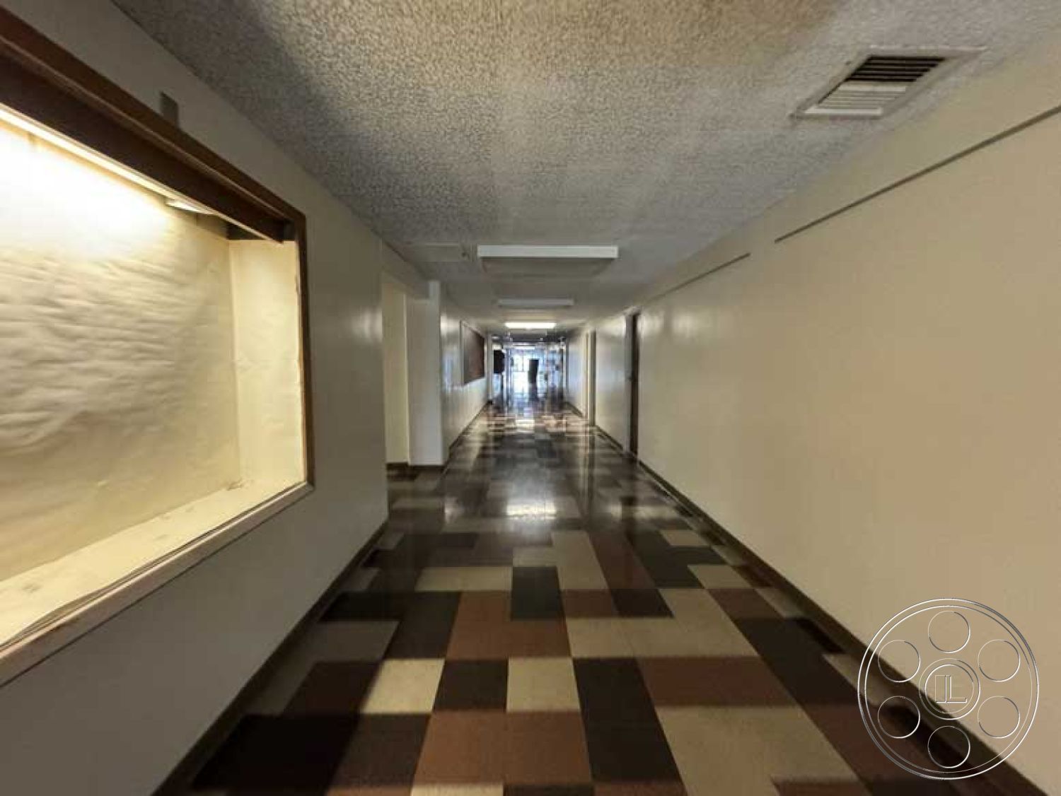 Old School - polished tile flooring, neutral color scheme, glass display case, acoustic ceiling tiles, interior hallway, white painted walls, commercial building interior, fluorescent ceiling lights, checkerboard tile design, narrow corridor layout, walls with minimal decor, long hallway perspective