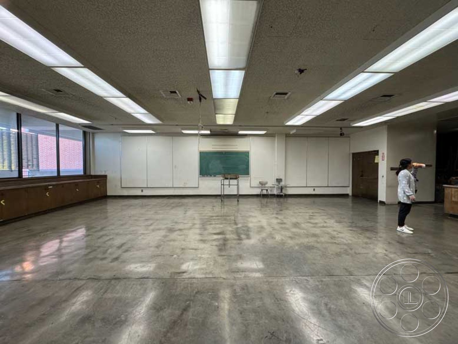 Old School - wood cabinetry, polished concrete flooring, chalkboard wall, acoustic tile ceiling, large windows with blinds, fluorescent ceiling lighting, classroom setting