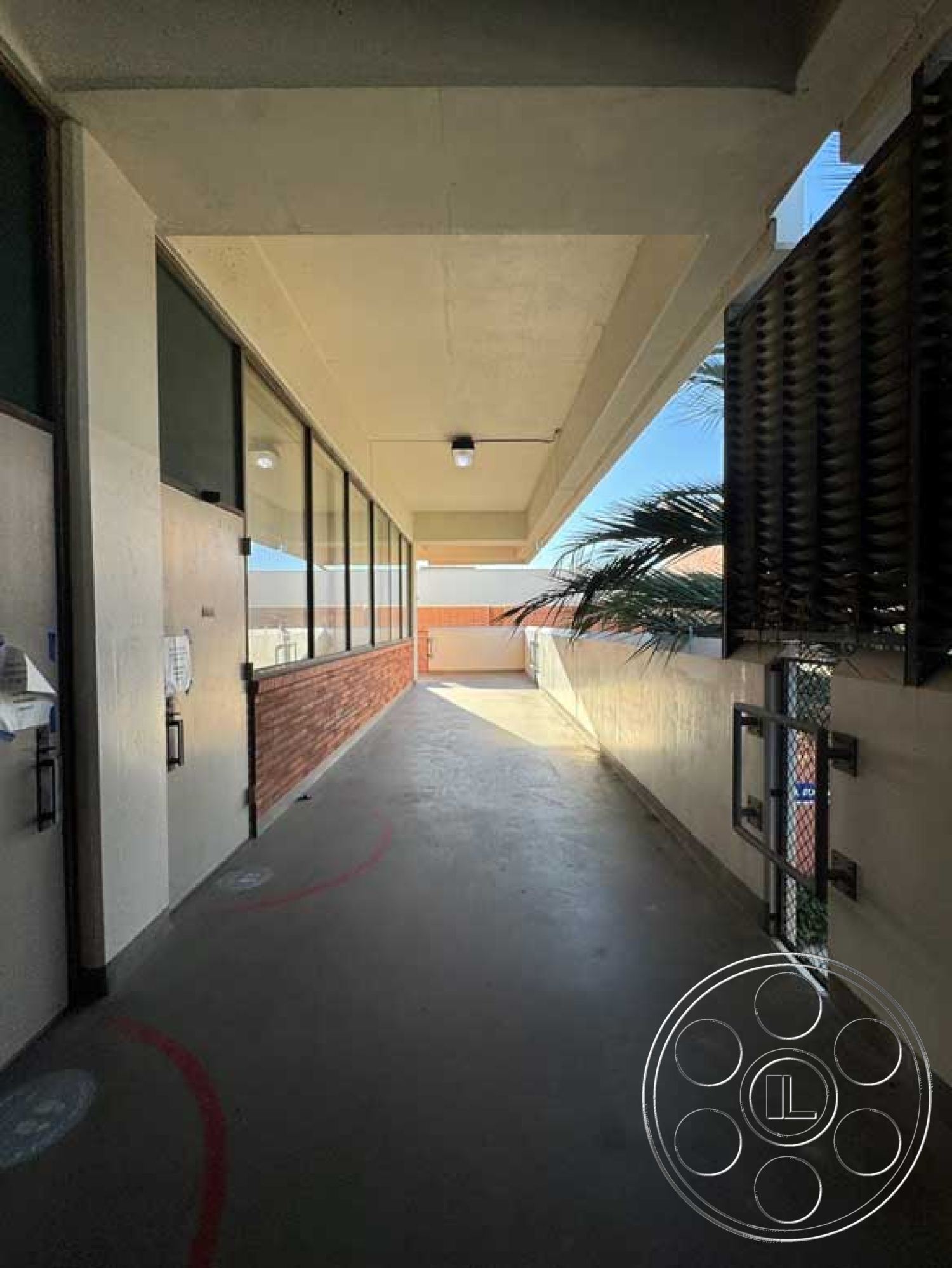 Old School - contemporary style, low-maintenance landscaping, floor-to-ceiling windows, brick accent wall, concrete walkway, exposed concrete ceiling, outdoor lighting fixtures, sunny urban setting, geometric architectural design, exterior corridor, modern stair railing, palm tree environment, open-air hallway, steel fence, multi-family housing complex, access door systems