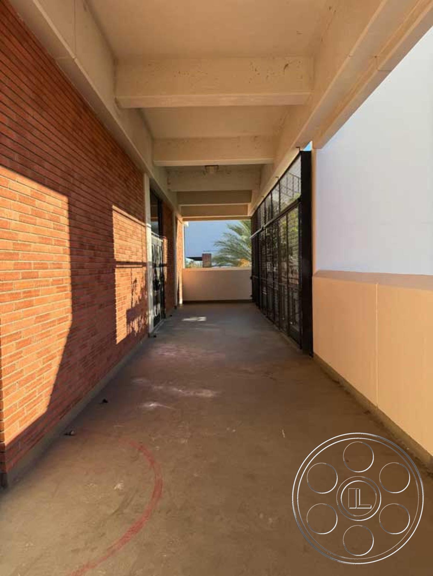 Old School - concrete floor, smooth concrete surface, urban setting, exposed brick wall, flowing natural light, concrete ceiling, sunlit interior, modern industrial design, minimalist architectural style, open corridor layout, metal framed windows, red brick masonry, glass partition to exterior