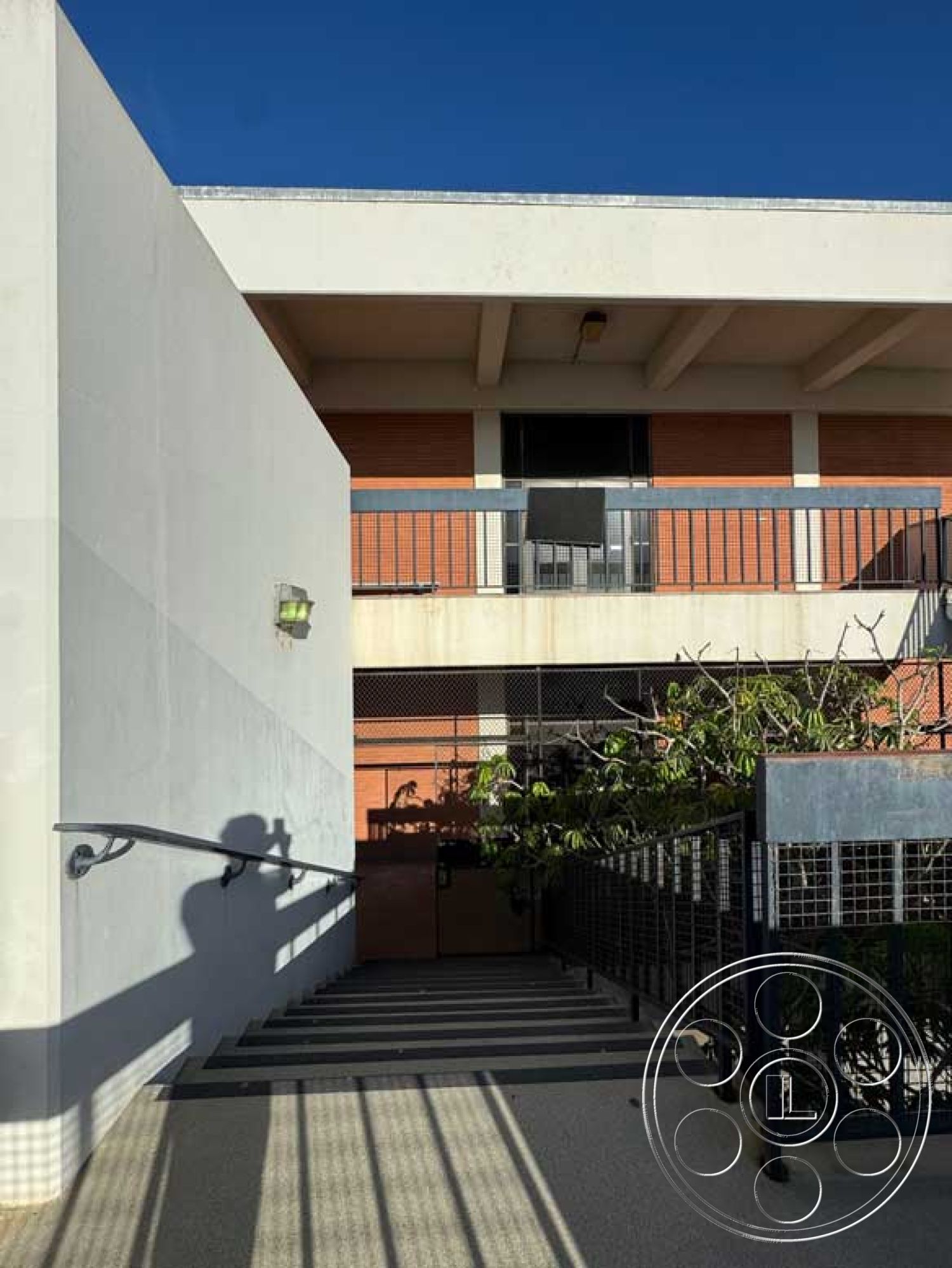 Old School - natural light, exterior, metal railing, concrete wall, brick facade, concrete steps, vaulted ceiling, modern architectural style, horizontal wood paneling, landscape greenery, glass balcony railing, urban courtyard, striped concrete paving, open air staircase, structured outdoor environment