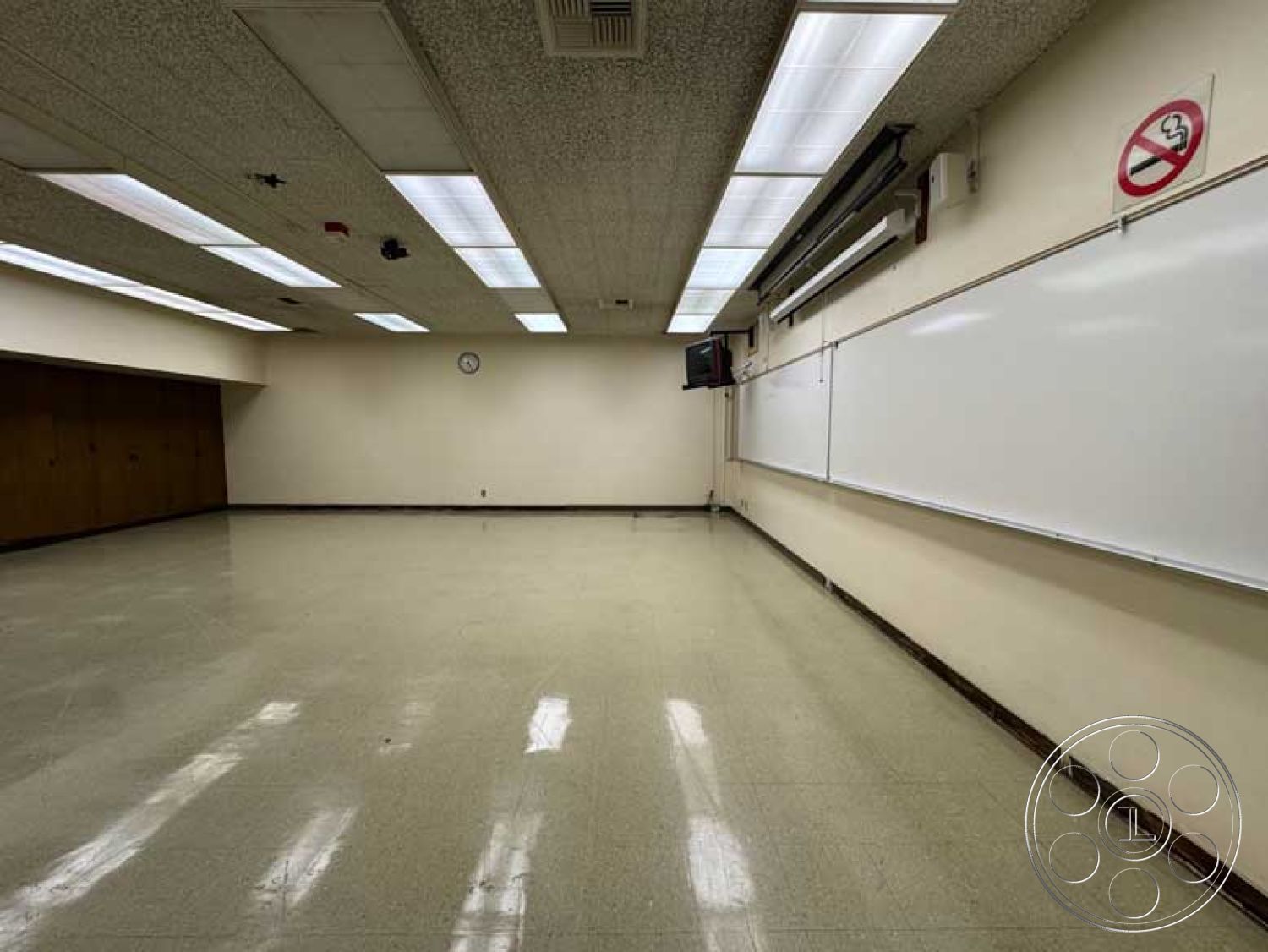 Old School - neutral color palette, fluorescent ceiling lights, textured ceiling tiles, modern classroom layout, whiteboard wall treatment, vinyl flooring classroom, drywall painted walls, brown wood paneling accents, exterior fabric bulletin boards, interior flexible seating arrangement