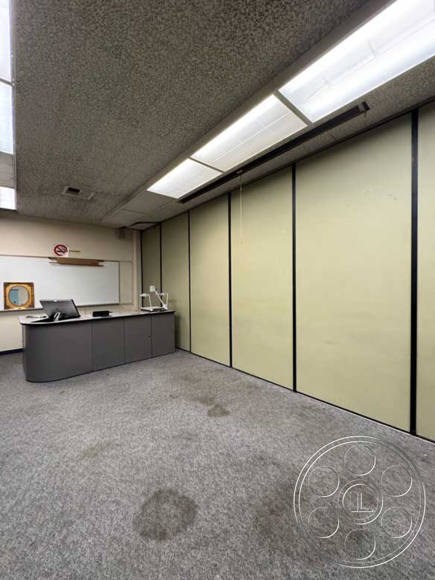 Old School - minimalist design, functional workspace, black cabinetry, grey carpet flooring, acoustic ceiling tiles, commercial office interior, fluorescent ceiling lights, whiteboard wall treatment, sliding partition walls, flat-panel countertop