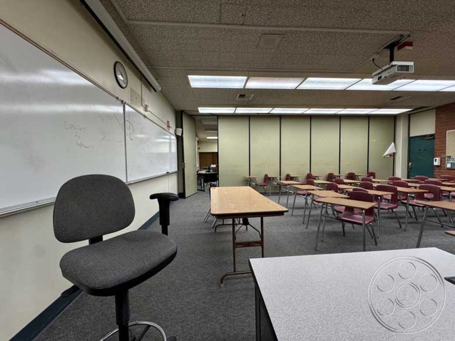 Old School - carpet flooring, metal folding chairs, interior classroom space, dry erase board wall treatment, built-in projection screen, open classroom layout, linear fluorescent ceiling lights, wooden classroom desks, Acoustic ceiling tiles, administrative office access, multi-purpose classroom layout, clock wall feature, green and beige wall panels