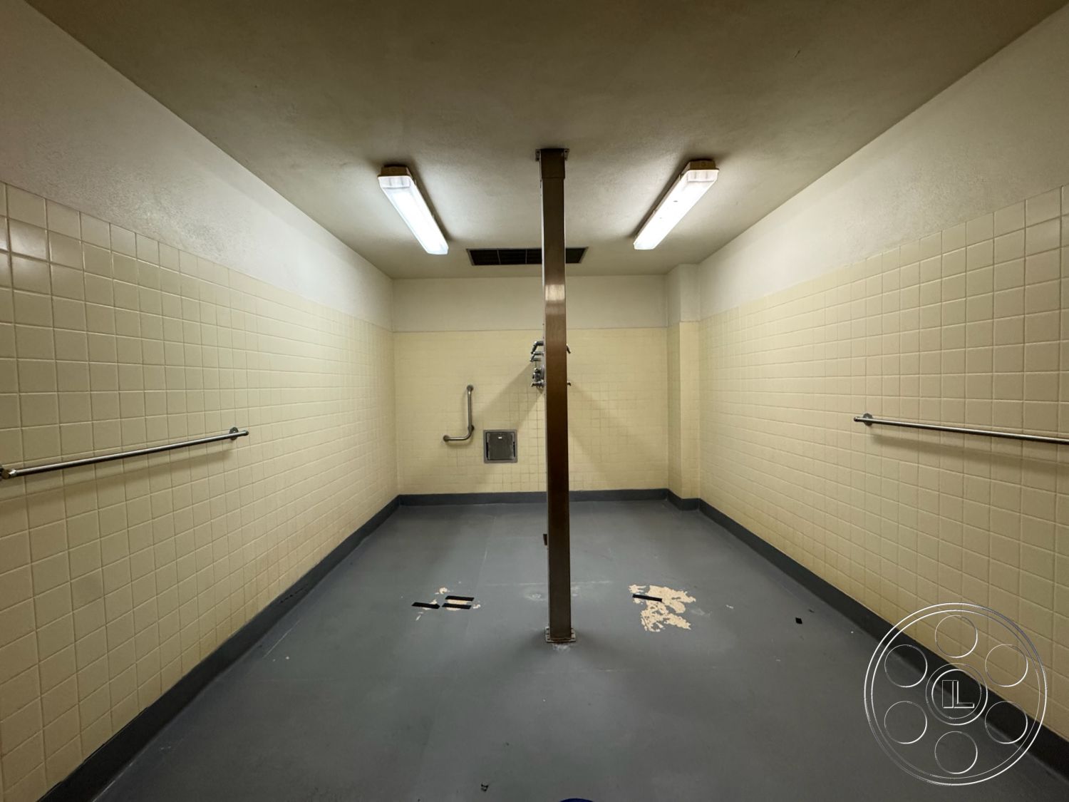 Old School - interior tiled bathroom walls, interior shower area with grab bars, interior commercial rubber flooring, interior fluorescent lighting fixtures, interior metal support column, interior beige ceramic wall tiles, interior plain ceiling panels, interior non-slip floor surface, interior exposed plumbing fixtures