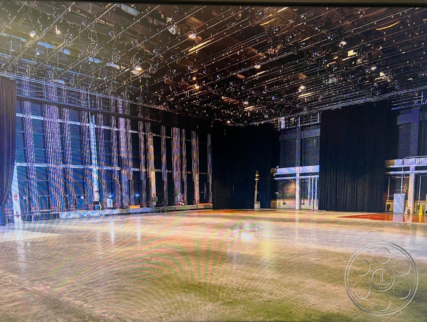 Stage 33 - industrial lighting fixtures, auditorium style seating, large glass entrance doors, black curtain backdrop, open performance space, hardwood floor accents, high ceiling height, exposed steel beams ceiling, polished concrete stage floor, adjustable stage rigging, soundproofed wall panels, lighting grid system, flexible floor plan, interior performance area, backstage accessibility features