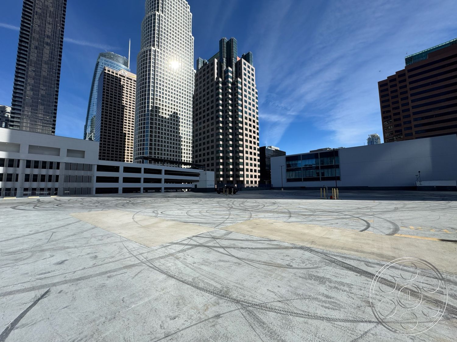 Rooftop 6 - exterior, smooth concrete surface, urban setting, glass facade, open outdoor space, city skyline view, exposed concrete, commercial architecture, flat roof design, steel structural elements, urban parking lot, concrete rooftop, modern high-rise buildings, surrounding skyscrapers