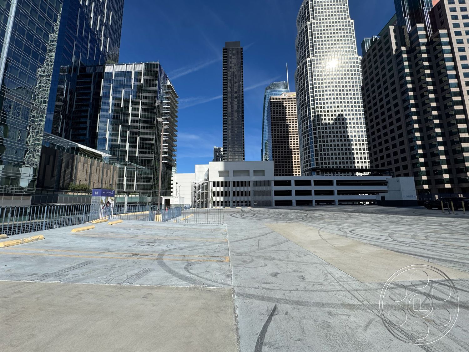 Rooftop 6 - exterior, minimalist design elements, urban skyline view, high-rise buildings, commercial architecture, modern urban setting, smooth concrete finish, surrounding cityscape, concrete parking lot surface, glass skyscraper facades, steel railing features, open parking area layout