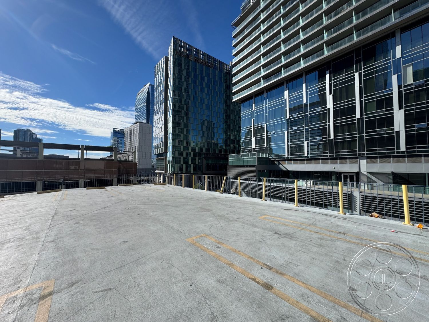 Rooftop 6 - urban setting, commercial building, steel railing, modern exterior, minimalistic design elements, glass curtain wall facade, flat rooftop, open urban space, panoramic skyline view, rectangular building shapes, concrete parking deck floor, high-rise contemporary architecture, photovoltaic panels (if applicable), geometric building forms