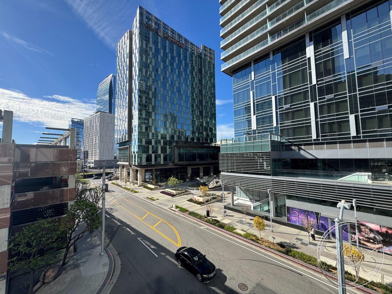 Rooftop 6 - glass facade office building exterior, steel frame construction exterior, exposed concrete columns exterior, modern rectangular high-rise structure exterior, floor-to-ceiling glass windows exterior, concrete sidewalk with landscaping exterior, urban cityscape setting exterior, commercial plaza area exterior, tree-lined street with pedestrian walkways exterior, sustainable design elements exterior, reflective glass surfaces exterior, urban environment setting exterior, modern architectural lines exterior, mixed-use development exterior