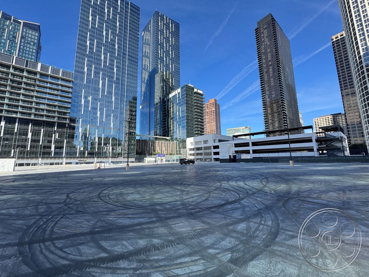 Rooftop 6 - exterior, modern architectural style, concrete parking lot surface, urban city skyline view, open urban space, glass skyscrapers, steel-framed buildings, reflected light from glass facades, asphalt drive lanes, concrete sidewalk borders