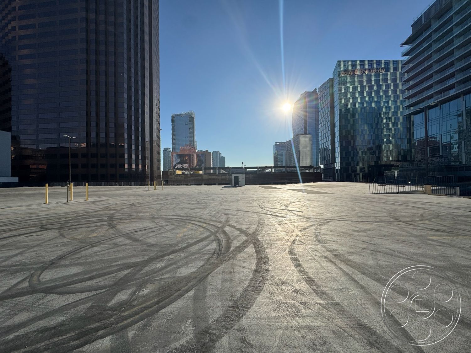 Rooftop 6 - open urban space, polished concrete surface, steel light poles, surrounding skyscrapers, exterior concrete parking lot surface, high-rise glass building facade, modern urban skyline view, reflected sunlight on asphalt, commercial architectural design, clean lines of contemporary architecture